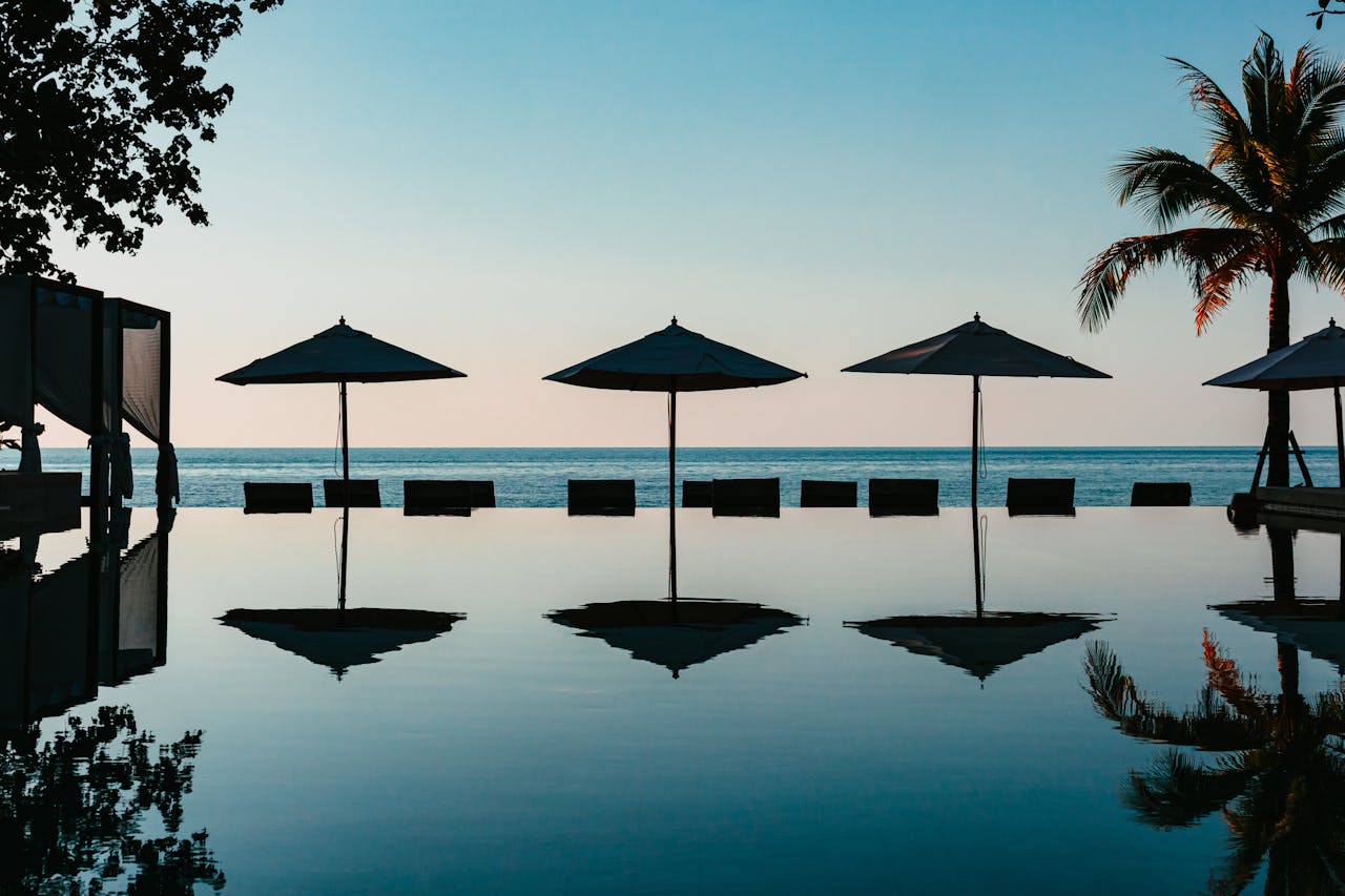 umbrellas on the edge of the swimming pool with view of the sea in a tropical resort